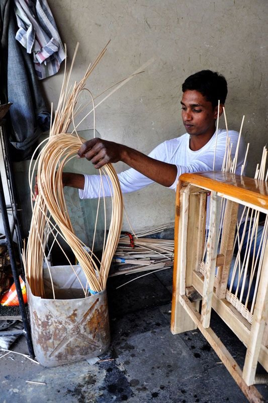 Artisan weaving [rattan core](https://rattanwickerandcane.com/2024/10/the-benefits-of-rattan-furniture-for-coastal-homes/)[^1] into a chair frame